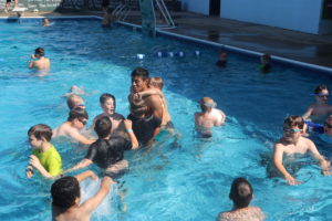 campers and counselor in pool