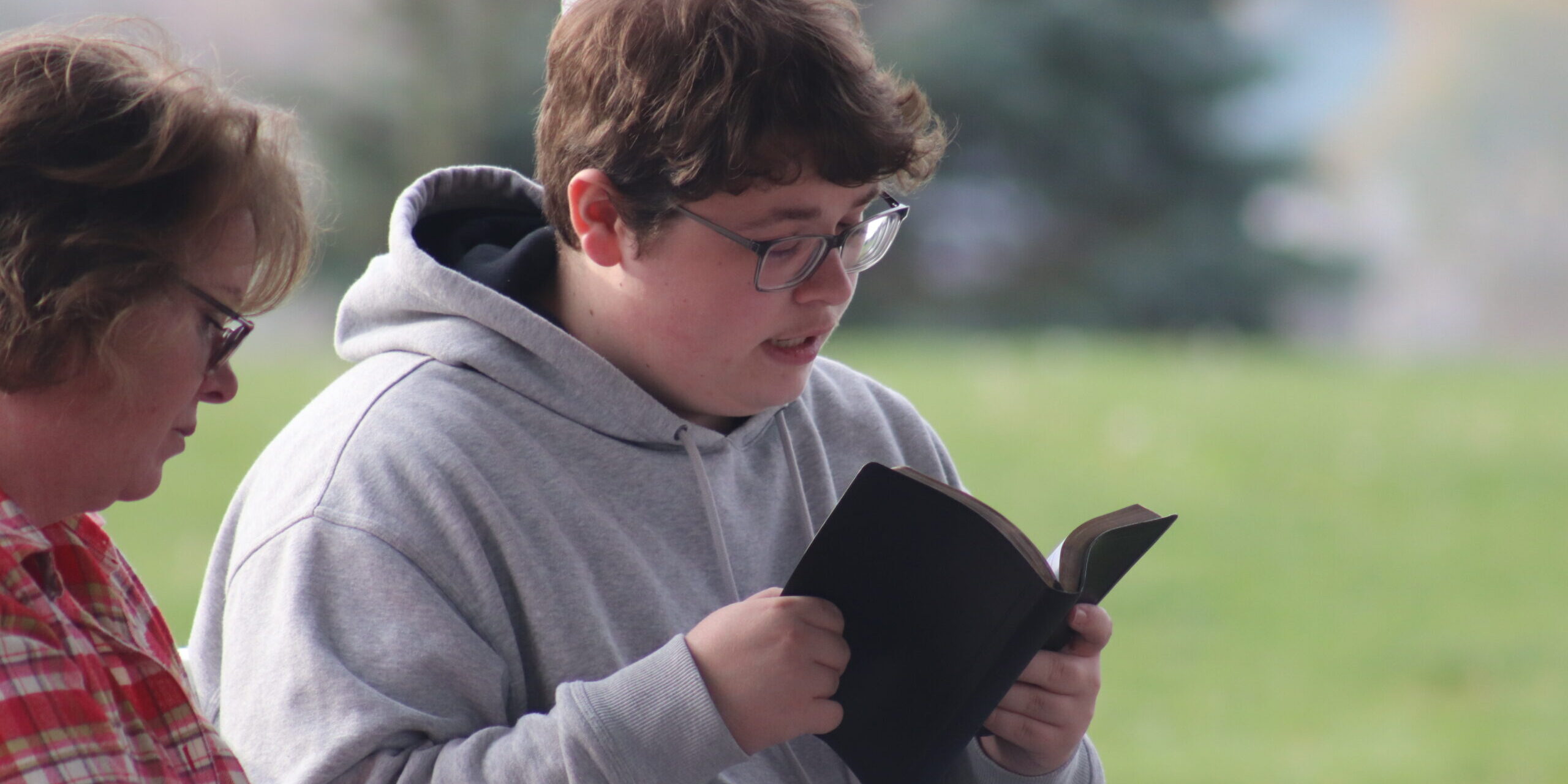 Momentum Camper reading Bible with leader